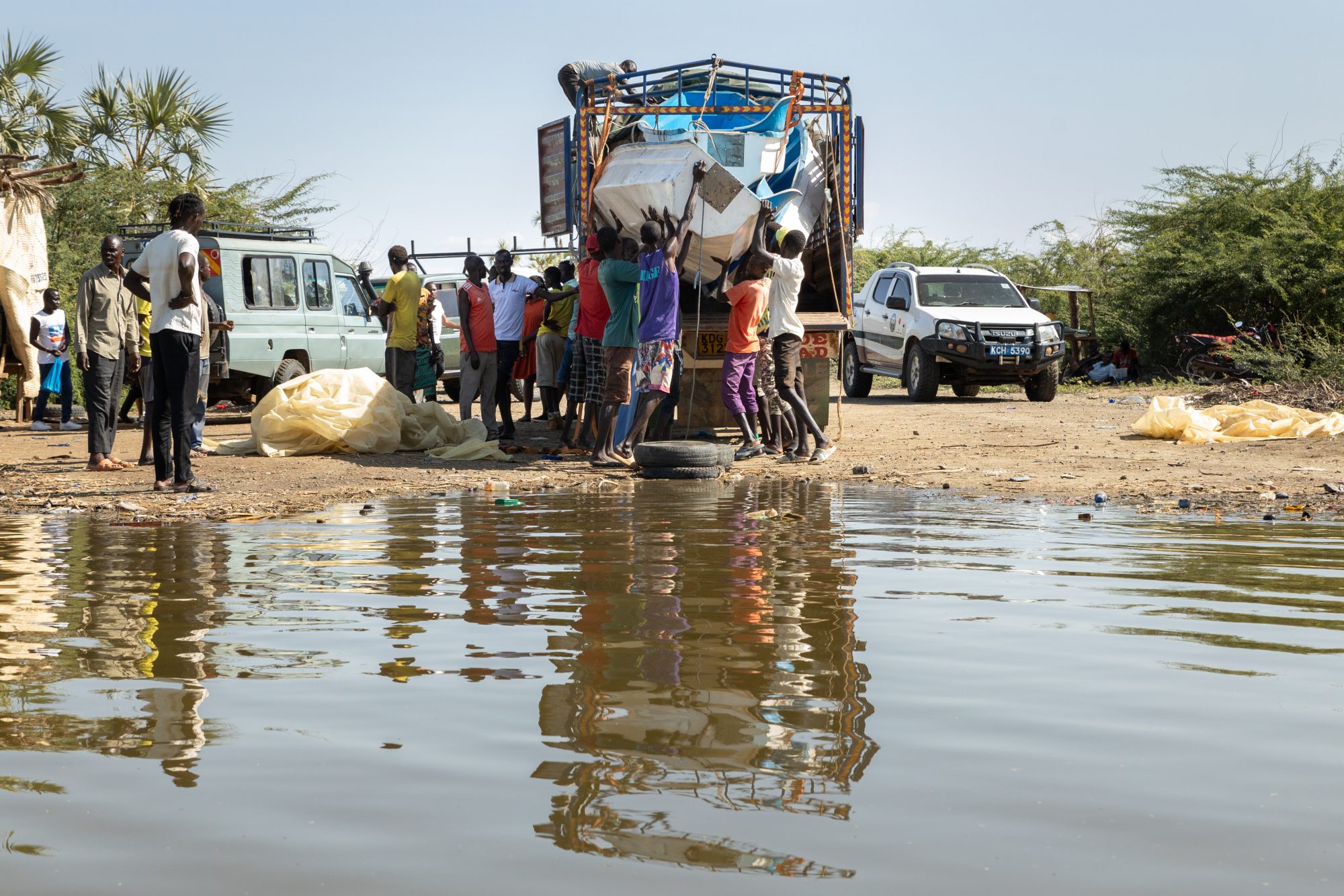 Fisher folk along Natole shores receiving modern boats donated by DCA to help improve their catches and livelihoods.