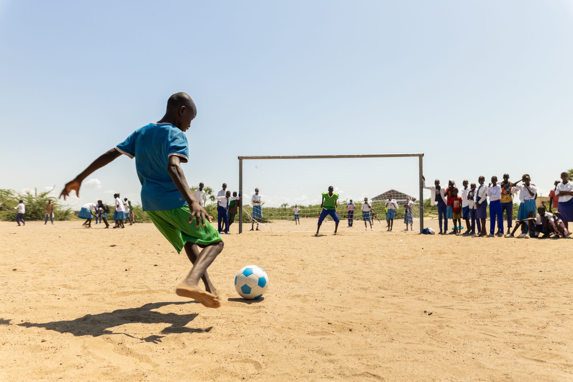 Students from Natole Primary School playing football, using kits and sporting facilities donated by DCA. Turkana County, Kenya.